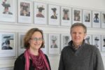 Bild von Prof. Megow (l) mit Prof. Teich vor der Wand der Bilder von abgeschlossenen Promotionen